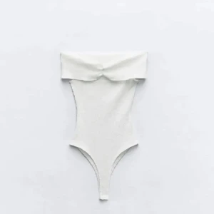 Vit axelbandslös bodysuit - Snygg vit axelbandslös body med en elegant offshoulder-design. Perfekt till fest med jeans, kjol eller kostymbyxor!💥 köpt på Plick men passade tyvärr inte mig. (Zara lappen är bort klippt) 