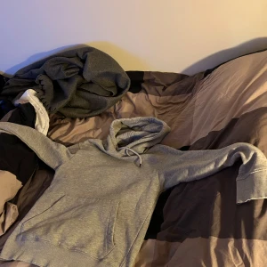 Grå hoodie från Jack & Jones - Säljer en stilren grå hoodie från Jack & Jones. Den har en klassisk design med en stor ficka framtill och justerbar huva med dragsko. Perfekt för en avslappnad look.