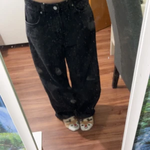 Svarta jeansbyxor - Säljer ett par svarta jeansbyxor med loose passform. Byxorna har en hög midja och klassisk femficksdesign. Perfekta för en avslappnad stil.