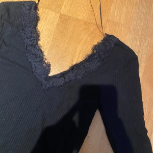 Tröja från new yorker -  svart ribbad topp från new yorker  med spetsdetaljer längs v-ringningen. 