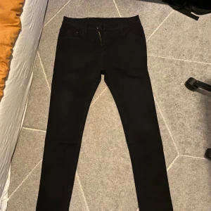 Svarta jeans - Snygga svarta jeans med slim passform och dragkedja. Perfekta för en stilren look.