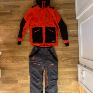 Skidkläder, Everest ADV - Säljer dessa skid/snowboard kläder pågrund av att jag har vuxit ur dem, hann bara använda dem 1 skidsemester i Österrike, så dem är som nya!  Jackan och byxorna är super sköna och bekväma och byxorna har ”TCS Waterproof” så dem är helt vattentäta. Jackan har ”TCS Waterresist” så den tål vatten, men är inte helt vattentät. Jackan har också snö skydd vilket ni kan se på bilden.  Byxorna har även RECCO© Technology vilket gör än spårbar för dem som ska rädda dig i tillexempel en lavin eller annat.