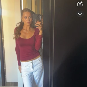 Vinröd långärmad topp - Snygg vinröd topp med lång ärm och djup urringning. Perfekt för en stilren look. Den är ifrån Nelly! 