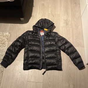 Svart dunjacka från Parajumpers - Säljer en svart dunjacka från Parajumper perfekt nu under vintern och våren. Säljer den för att den är för liten för mig som är 177 lång men passar den som är 160 - 173 ungefär, det är ett litet hål på höger arm men det syns inte om du inte kolla noga syns på bild 5. Skriv privat vid fler bilder!! Ny pris 5299