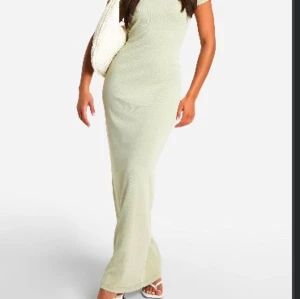 Olivgrön långklänning - Snygg olivgrön långklänning. Klänningen har en tight passform och är ärmlös, vilket gör den perfekt för varmare dagar. Den enkla designen ger en stilren look.