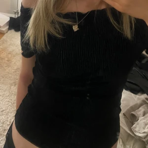 Svart offshoulder topp - Snygg svart offshoulder topp med ribbad textur i sammet. Perfekt för en stilren look. Toppen har korta ärmar och en smickrande passform⭐️💋