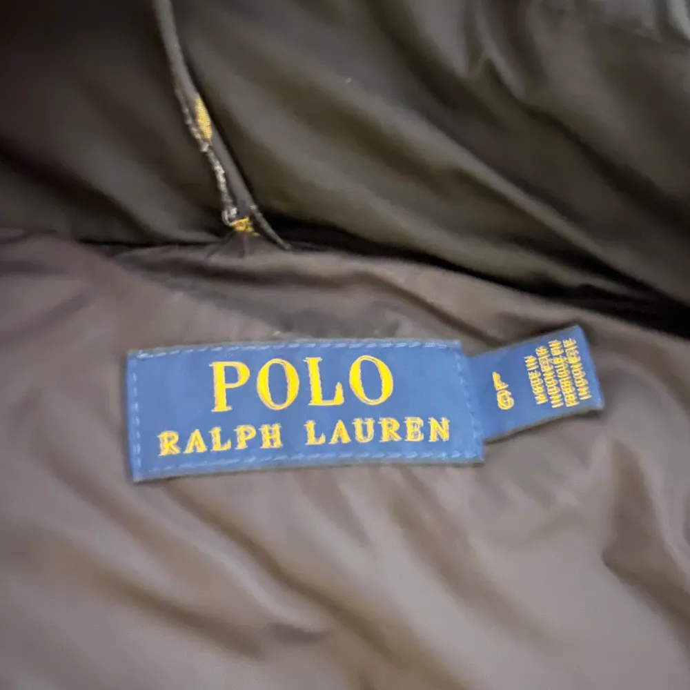 Snygg svart dunjacka från Polo Ralph Lauren med huva och dragkedja. Jackan  är perfekt för kyligare väder. Storlek L men passar nog M också. Man får en monclermössa på köpet. Takit.