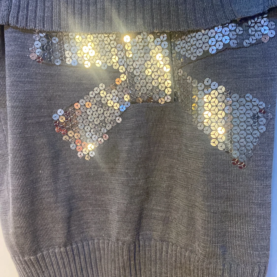 Säljer en grå tröja med en rosett (paljetter  - 91