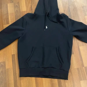 Svart hoodie från Ralph Lauren - Säljer en stilren svart hoodie från Ralph Lauren med det klassiska logotypbroderiet på bröstet. Skriv om du har några mer funderingar✍️📄 Priset kan gå ned vid snabb affär🤝
