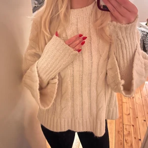 Vit stickad tröja - Vit stickad tröja med kabelstickat mönster från Zara. Den har som dubbel ärmar, en tajtare och så går de en kortare utanpå. 