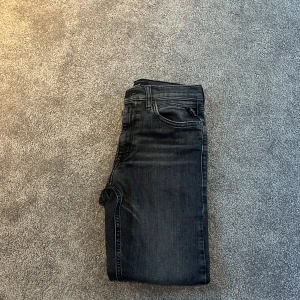 Mörkgråa jeans från Replay - Snygga svarta jeans från Replay med klassisk femficksdesign och en diskret tvätt för en stilren look. Perfekta för en avslappnad stil med en touch av elegans. Modellen THAD. Storlek 152. Sitter slim/regular. (Beror ju lite på hur man vill att de ska sitta. Om ni har någon fråga eller undrar något så är det bara att skriva. Pris går att diskutera! MVH Jacob