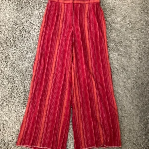 Randiga röda loosefit byxor - Rostfärgade randiga loosefit tygbyxor. Byxorna är använda men är i gott skick. Passar strl S. Meddela gärna angående eventuella frågor. :)