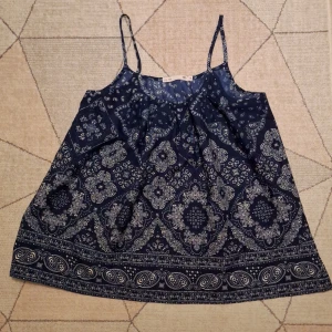 Blåmönstrat linne  - Ett blåmönstrat linne i storlek S. I siden aktigt material. (Banden är ej justerbara) Säljer pga att den inte används. Den är köpt secondhand, men skulle säga att den ser ny ut!✨️ PS står ej för frakt!