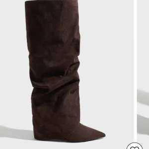 Folded boots - Jätte fina populära folded boots från Nelly, helt slutsålda på hemsidan. Jätte fin mörk  brun färg och perfekt nu till hösten! Väldigt bekväma klackar! Använda fåtal gånger 