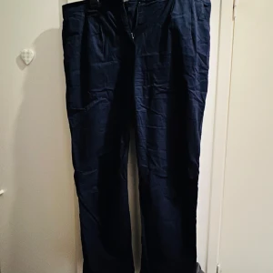 Mörkblå chinos från Bonprix - Säljer ett par snygga mörkblå chinos från Bonprix. De är i bra skick och perfekta för både vardag och fest. Byxorna har en klassisk passform med dragkedja och knappar. Perfekta för höst och vår!