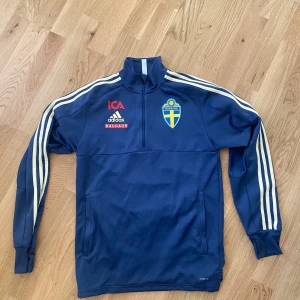 Sverige set - Set med överdragströja, T-shirt och shorts.  Alla i storlek S.  Dragkedja fickor på shortsen och en stor ficka på överdragströjan.  Ljusgula ränder