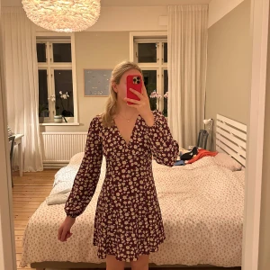 Blommig klänning - Långärmad klänning med blommigt mönster från NAKD.