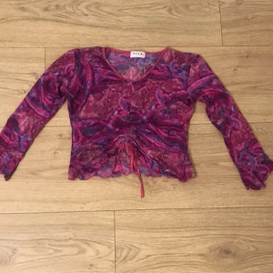 VILA tröja - Vila tröja i ett snyggt mönster. Volanger längst ner i armarna samt längst ner på tröjan. Man kan spänna åt med hjälp av snören för att få den mer v-ringad. Står storlek L men passar mig som har XS. Jättebra skick och endast använt 1 gång.