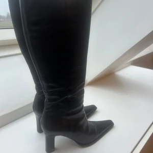Trendiga höga svarta stövlar - Klack stövlar från Bronx i väldigt bra kvalite, storlek 37 med ganska smal fot, inga skador och ser ut som nya, ny pris 2 495kr