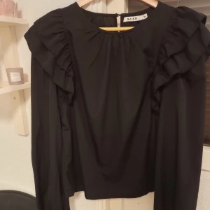 Långärmad med volanger (FRILL BLOUSE) - Säljer en tröja med volanger, strl 36 från NA-KD, mycket bra skick, använd cirka 5 gånger, säljer den för 80kr + frakt! 