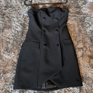 Svart klänning  - En svart klänning utan Axel band. Använd 1 gång, storlek XS men passar även en S.