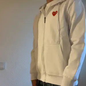 Unik vit CDG zip hoodie med storleken M i topp skick 9/10 . Tagg medföljer vid köp. (Fraktar endast)