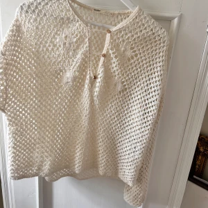 Vit virkad tröja från Pull&Bear - Säljer en superfin vit virkad tröja från Pull&Bear. Den har en luftig design med knappar framtill och är perfekt för sommarens alla tillfällen. Tröjan är i nyskick och passar perfekt till både stranden och en avslappnad dag på stan. 🌞
