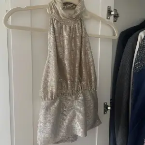 Super fin glittrig halterneck topp, silvrig/guld glittrig, bra i skick och är stretchig så passar även lite större storlekar också!💗