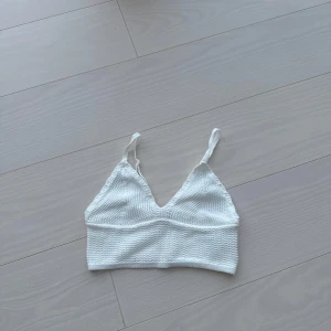 Vit ribbad linnetopp - Säljer en vit ribbad linnetopp med smala axelband. Perfekt för varma dagar och enkel att matcha med olika outfits. Exempel bikini cover up till sommaren!!