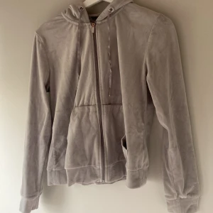 Grå hoodie med dragkedja - Säljer en mysig grå hoodie med dragkedja och huva. Den har långa ärmar och är tillverkad i ett mjukt material som ger en skön känsla. Perfekt för en avslappnad stil.