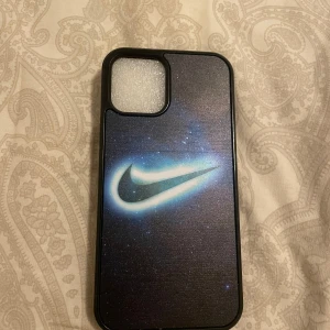 Mobilskal med Nike-logga - Snyggt mobilskal för iPhone 12 med en  Nike-logga i ett rymdinspirerat motiv. Skalet har en svart kant och är designat för att skydda din telefon med stil. Perfekt för dig som vill ha en sportig look på mobilen.
