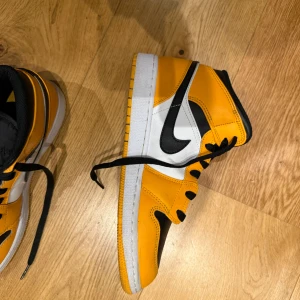 Nike Air Jordans i svart och orange - Snygga Nike Air Jordans i en cool kombination av svart och orange. Skorna har klassisk snörning och den ikoniska Nike-loggan på sidan. Perfekta för att ge din stil ett lyft! OBS skorna kommer med skydd.
