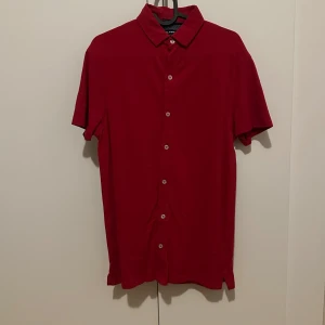 Röd kortärmad skjorta från Alcott - Snygg röd kortärmad skjorta från Alcott i storlek M. Skjortan har en klassisk krage och knappar framtill. Perfekt för en stilren look. Skick 10/10 aldrig använd sitter bekvämt. 