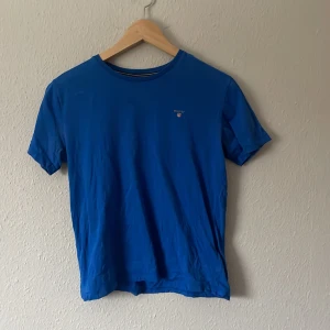 Blå t-shirt från GANT - Snygg blå t-shirt från GANT med rund halsringning. Perfekt för en avslappnad stil. Tillverkad i mjukt material för extra komfort.