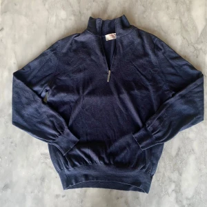 Mörkblå Gran sasso vintage half zip  - Skick: 7,5/10. Ena sidan av tagen i nacken har släppt men den sitter kvar. Från märket gran sasso i storlek M. Om du är osäker på om det kommer att passa kan du alltid fråga om mått!