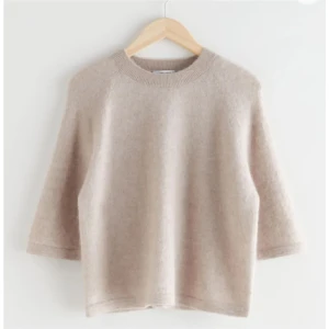 Other stories tröja - Säljer en stilren beige stickad tröja med trekvartsärm. Perfekt för lager-på-lager under kyligare dagar. Enkel och tidlös design som passar till det mesta!❤️❤️
