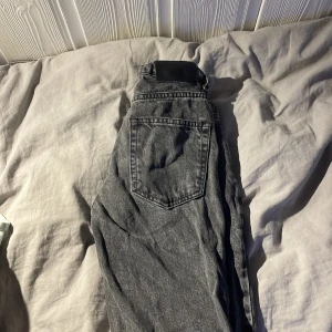 Jeans från grunt  - Snygga grå jeansbyxor med en klassisk femficksdesign. De har en rak passform och är perfekta för en avslappnad stil. Byxorna har en dragkedja och knapp framtill stl 150-155.