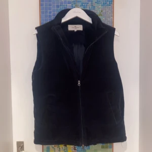 John Henric Manchester väst - Snygg mörkblå väst i manchester från John Henric. Väst med dragkedja framtill och en stilren design. Två innefickor och två ytterfickor vilket gör det extremt praktiskt! Väldigt bra skick och i storlek Medium!