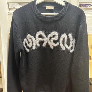Svart tröja från Marni - Snygg svart tröja från Marni med ett unikt vitt mönster framtill. Tröjan har en rund halsringning och långa ärmar, perfekt för en stilren look.