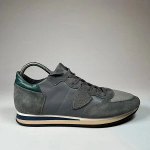 PHILIPPE MODEL TRPZ - Snygga grå sneakers med mockadetaljer och mörkgröna inslag. Skorna har en klassisk design med snörning och en bekväm sula. Perfekta för en stilren vardagslook. Pris kan diskuteras 