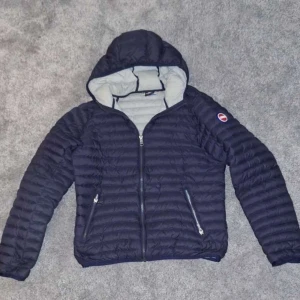 Marin blå jacka från Colmar - Säljer en marin blå quiltad jacka från Colmar med huva och dragkedja. Den är i bra skick och riktigt fet och den har bara anvädts varsamt, riktigt bra för vardagen!! pris kan diskuteras och var nu inte rädd att höra av dig vid några funderingar! 😉🤩🍸🍾