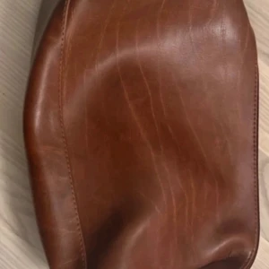 Necessär för man - Snygg brun necessär i skinn med dragkedja. Perfekt för att hålla dina saker säkra och stiliga.