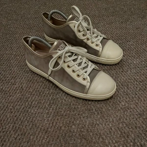 Grå sneakers från Tod's - Snygga grå sneakers från Tod's med snörning och vita detaljer. Skorna har en klassisk design med rund tå och är perfekta för våren och sommaren. Nypris ca 6000