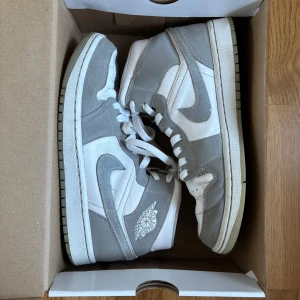 Jordan 1 mid, wolf gray  - Säljer WMNS Nike air jordan 1 mid i färgen white/aluminium-Wolf gray. Köptes för ca. 3 år sedan och har tecken på användning men varit väl omhändertagna. Köptes för ca. 2800 kr. Skriv vid eventuella frågor! 