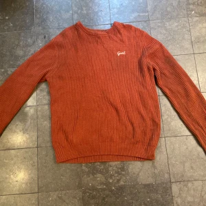Orange stickad tröja från GANT - Säljer en snygg orange stickad tröja från GANT i storlek XL. Tröjan har en klassisk design med ribbad struktur och är i gott skick.