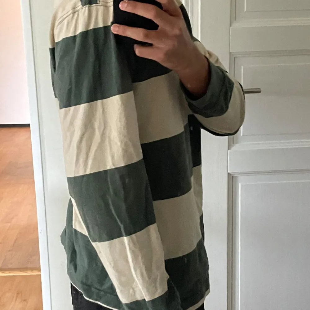 Säljer en randig tröja från H&M i storlek S. Den har breda ränder i grönt och beige och är perfekt för en avslappnad stil. Tröjan är långärmad och har en relaxed fit. Perfekt för höst och vår! Plagget är knappt använt.. Tröjor & Koftor.