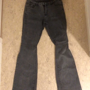 Grå bootcut jeans - Säljer ett par snygga grå bootcut jeans. De har en klassisk femficksdesign och är i bra skick. Perfekta för både vardag och fest!