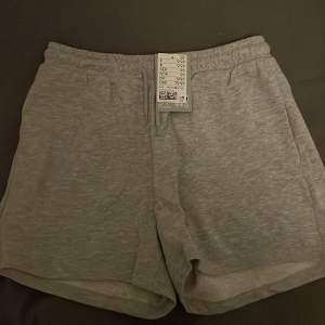 Säljer ett par grå mjukisshorts från H&M i storlek S. De är superbekväma och perfekta för en avslappnad dag hemma eller en snabb tur till affären. Shortsen har en elastisk midja och är gjorda i mjukt material. Perfekta för sommaren eller våren!