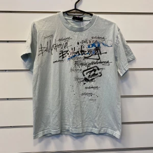 Billabong T-Shirt y2k graffiti - Billabong T-Shirt i ljusblå färg med massa graffiti detaljer. Rätt så boxy passform.  I bra skick men har en fläck som syns på sista fotot  Ingne storlekslapp men paasar som en boxy small, fråga efter mått!  Skriv ifall du har några fler frågor!