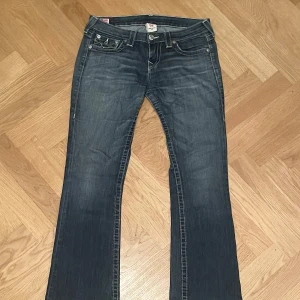 Snyggt slitna True Religion jeans 29 - Riktigt snygga vintage True Religion som är en aning Bootcut. Supermjuka och lite slitna längst ner, som de ska vara! Mått Midja ca. 40cm Inre benlängd ca. 72cm Yttre benlängd ca. 97cm Vidd nedtill ca. 22cm